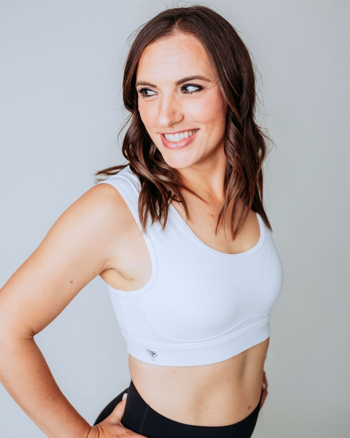 Woman wearing the ivory Pipperly Empower posture support sports bra