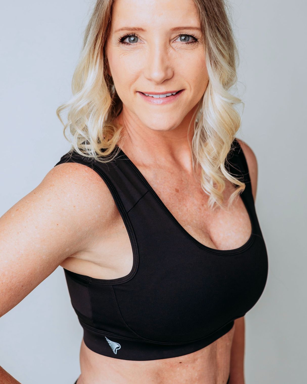 Woman wearing the obsidian Pipperly Empower posture support sports bra