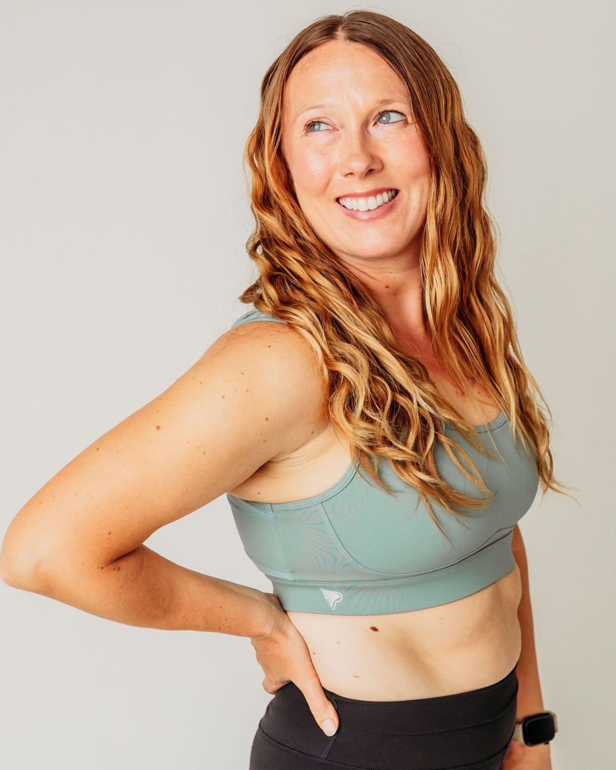 Woman wearing the juniper Pipperly Empower posture support sports bra